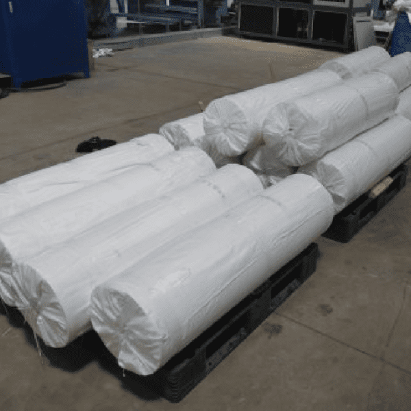 A bunch of rolls of plastic wrap on top of pallets.