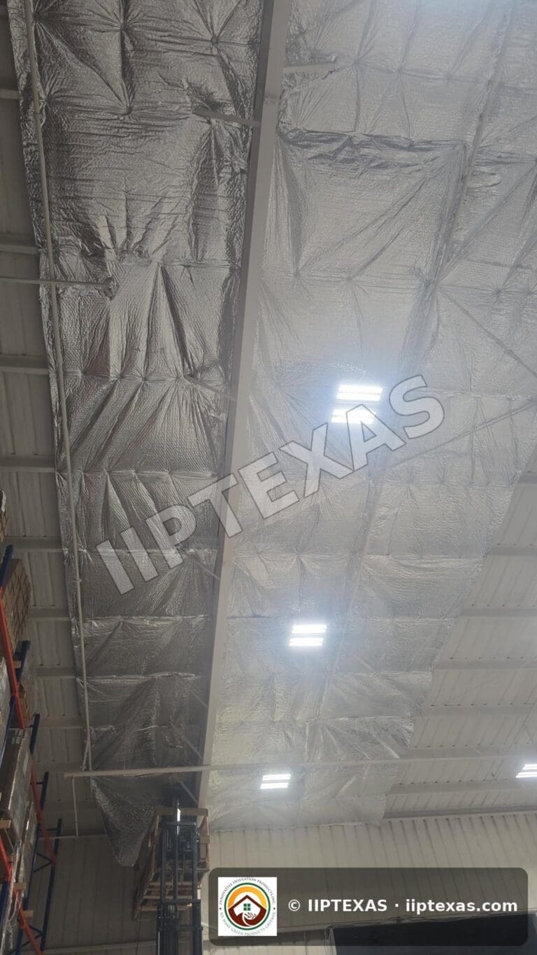 IIP Texas crew installing reflective bubble foil insulation under the roof of a metal building