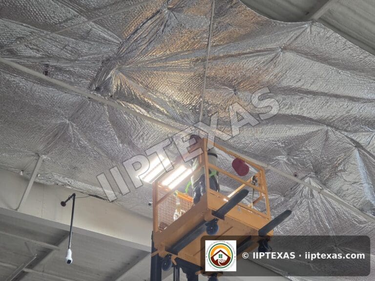 IIP Texas crew installing reflective bubble foil insulation under the roof of a metal building