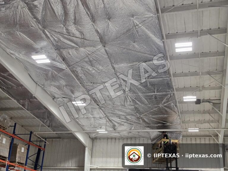 IIP Texas crew installing reflective bubble foil insulation under the roof of a metal building