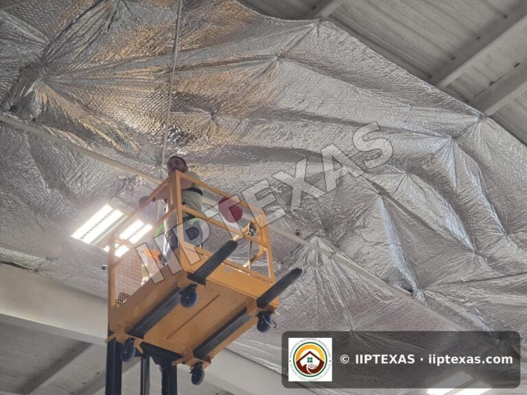 IIP Texas crew installing reflective bubble foil insulation under the roof of a metal building