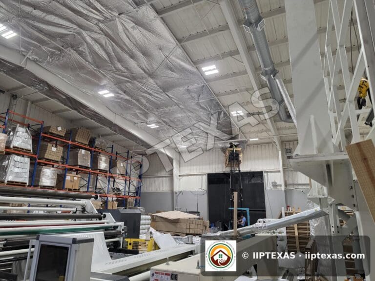 IIP Texas crew installing reflective bubble foil insulation under the roof of a metal building