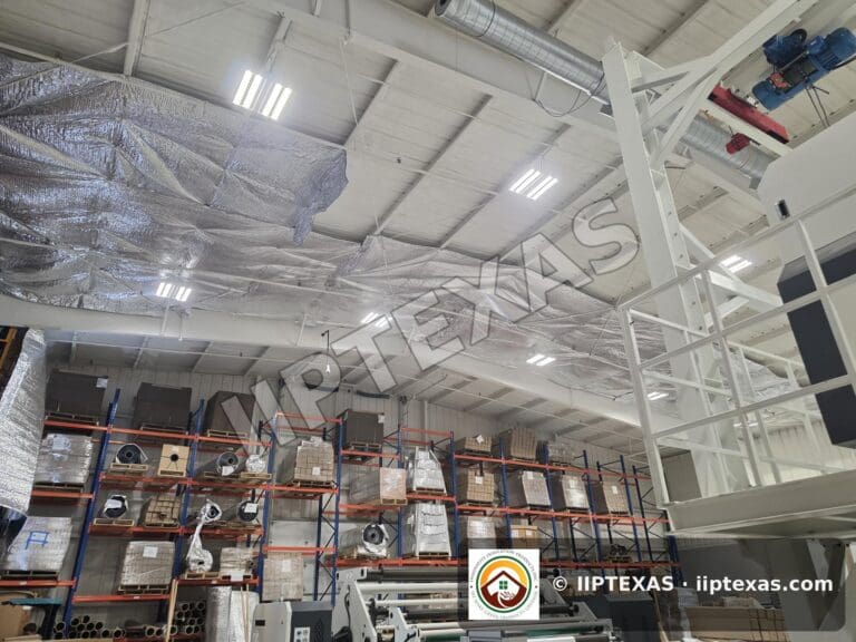 IIP Texas crew installing reflective bubble foil insulation under the roof of a metal building