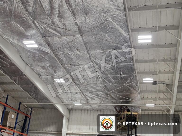 IIP Texas crew installing reflective bubble foil insulation under the roof of a metal building